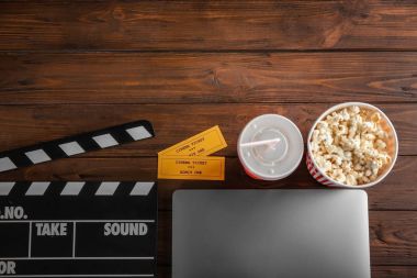 Dizüstü bilgisayar, sinema bileti ve fıçı tahtası ahşap arka plan, üstten görünüm kompozisyon