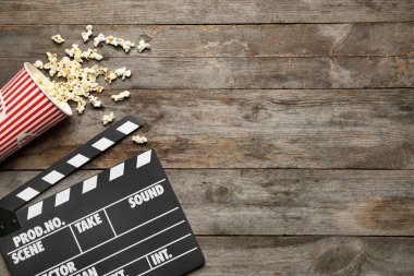 Film clapper ve ahşap arka plan, üstten görünüm üzerinde patlamış mısır