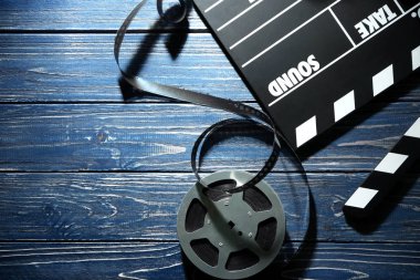 Film clapper ve reel ahşap arka plan, üstten görünüm