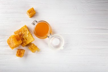 Kavanoz ve ahşap arka plan üzerinde peteğin aromatik tatlım