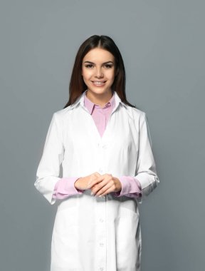 Genç kadın eczacı gri arka plan üzerinde
