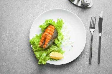 Lezzetli kızarmış alabalık marul ve gri arka plan, üstten görünüm sosu ile