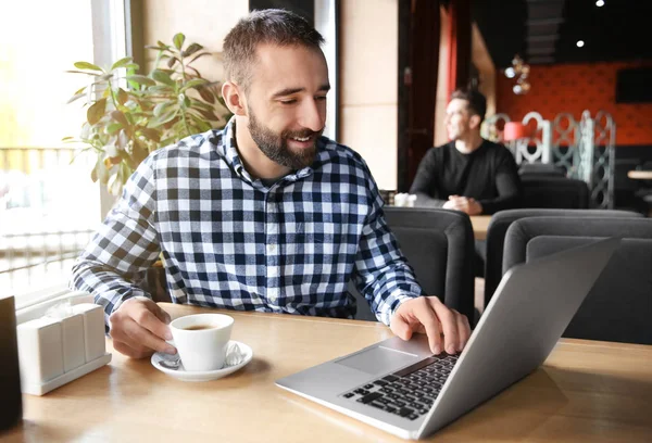 Hipster młody człowiek z kawy i laptopa w kawiarni — Zdjęcie stockowe