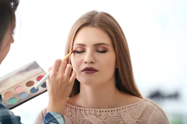 Professionell Konstnär Att Skapa Makeup För Vackra Modell Ljus Bakgrund — Stockfoto