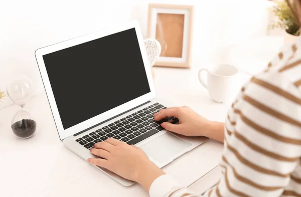 Jovem mulher trabalhando com laptop moderno à mesa — Fotografia de Stock