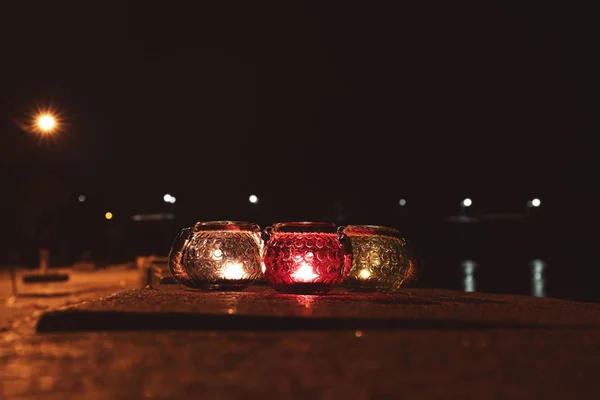 Gläser mit brennenden Kerzen in der Nacht, im Freien — Stockfoto