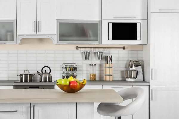 Interior de la cocina moderna con mesa de madera y horno microondas —  Fotos de Stock