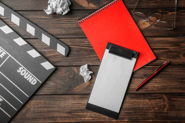 Composition with movie clapper, clipboard and notebook on wooden background, top view — Stock Photo, Image