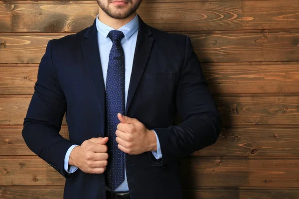 Hombre guapo en traje formal sobre fondo de madera, primer plano —  Fotos de Stock