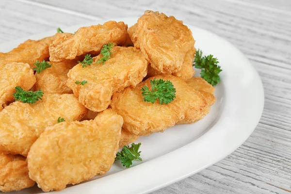 Prato com nuggets de frango saborosos na mesa — Fotografia de Stock