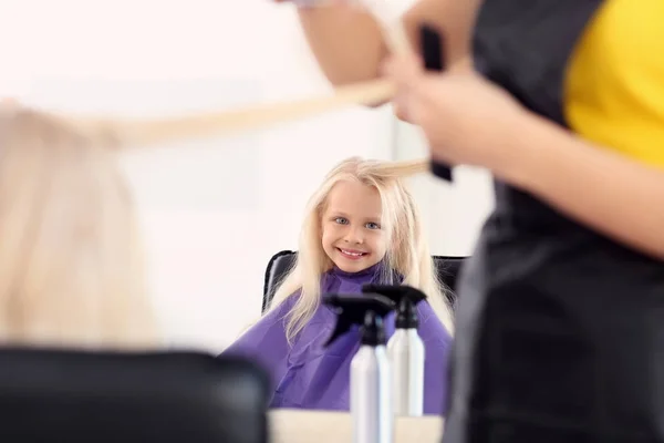 Femme coiffeuse travaillant avec une petite fille dans le salon — Photo