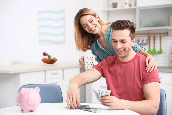 Jeune couple avec argent à la maison — Photo