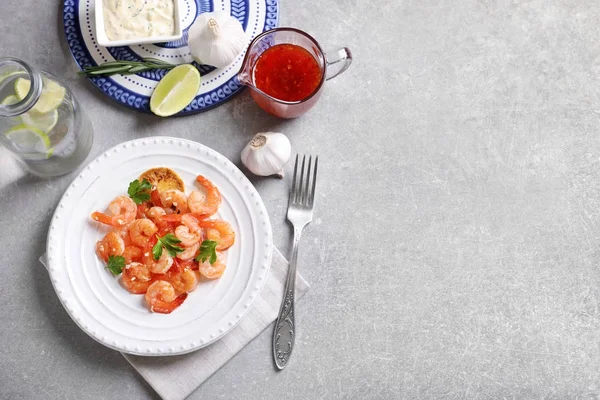 Το πιάτο με νοστιμότατες τηγανητές γαρίδες και το ψιλοκομμένο σκόρδο στο τραπέζι — Φωτογραφία Αρχείου