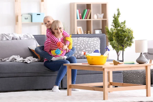 Petite fille et sa mère avec des fournitures de nettoyage à la maison — Photo