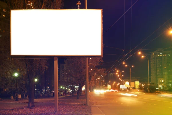 Tablero publicitario en blanco en la calle de la ciudad por la noche — Foto de Stock