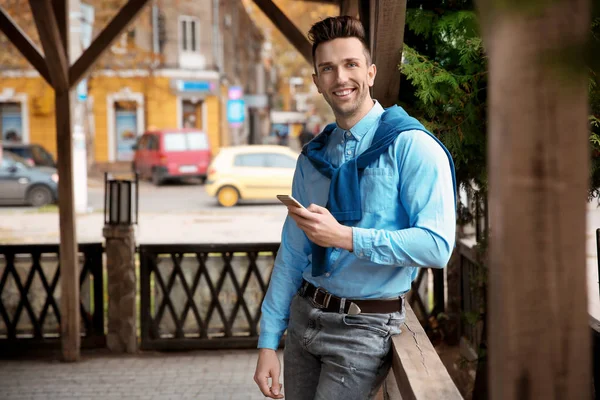 Retrato de un joven hipster con teléfono al aire libre —  Fotos de Stock