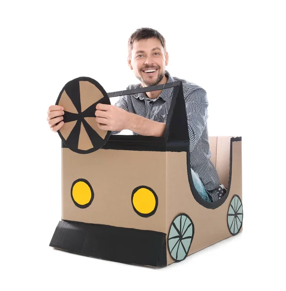 Young man dreaming of buying own auto while playing with cardboard car on white background — Stock Photo, Image