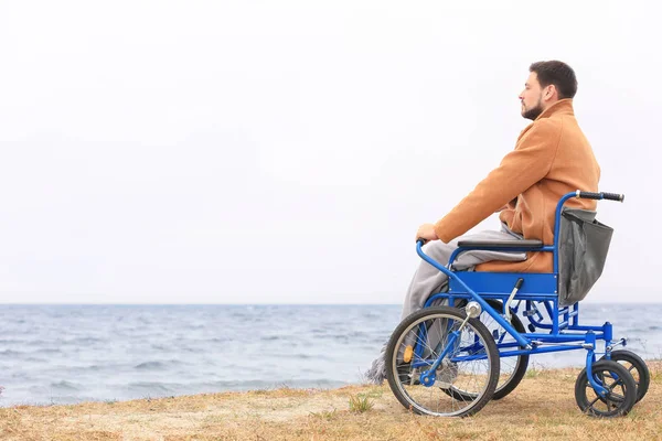 Man i rullstol vid havets strand — Stockfoto