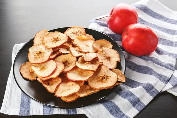 Тарелка с яблочными чипсами на столе — стоковое фото
