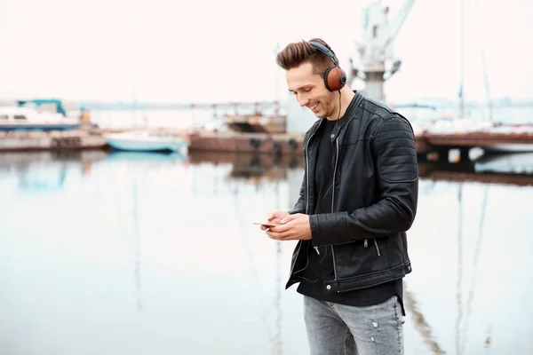 Portret van jonge hipster man met koptelefoon luisteren naar muziek in openlucht — Stockfoto
