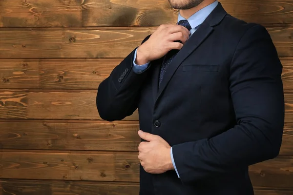 Hombre guapo en traje formal sobre fondo de madera, primer plano —  Fotos de Stock