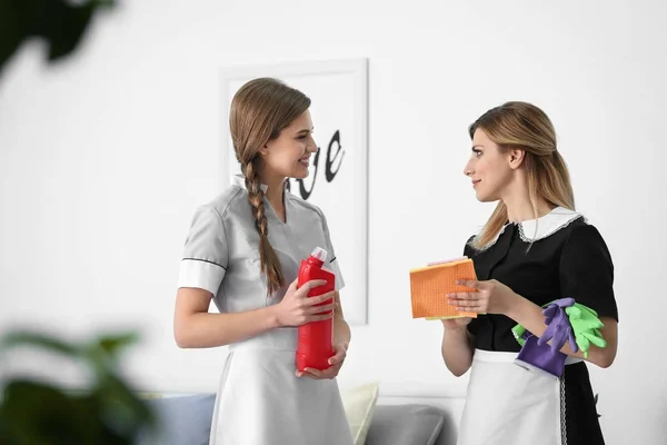 Kamermeisje in uniforme onderwijs stagiair binnenshuis — Stockfoto