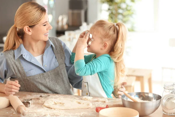 Mother and daughter having fun while  preparing cookies from dough indoors — Stock Photo, Image