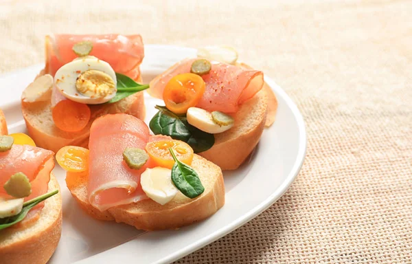 Prato com saborosas bruschettas frescas na mesa — Fotografia de Stock