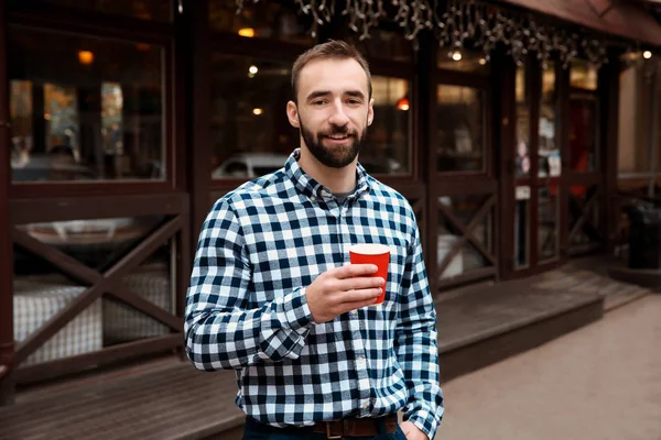 Giovane hipster uomo con una tazza di caffè all'aperto — Foto Stock