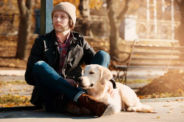 Guapo joven hipster con perro al aire libre —  Fotos de Stock