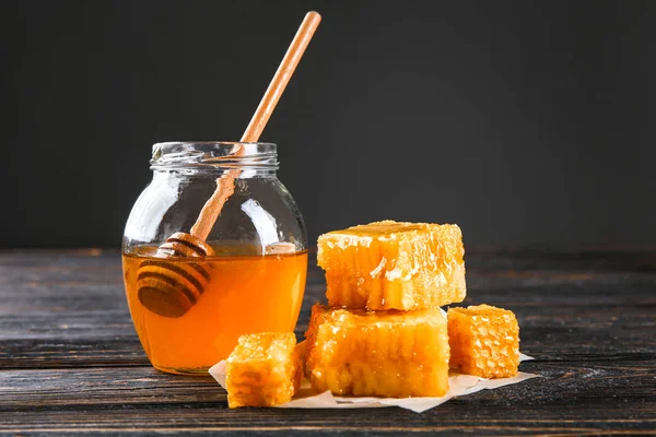 Aromatische honing in de pot en honingraten op houten tafel — Stockfoto