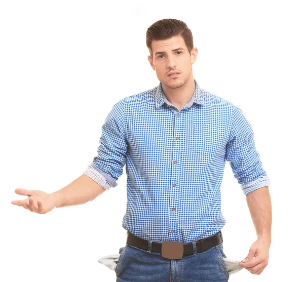 Handsome young man showing empty pockets on white background — Stock Photo, Image