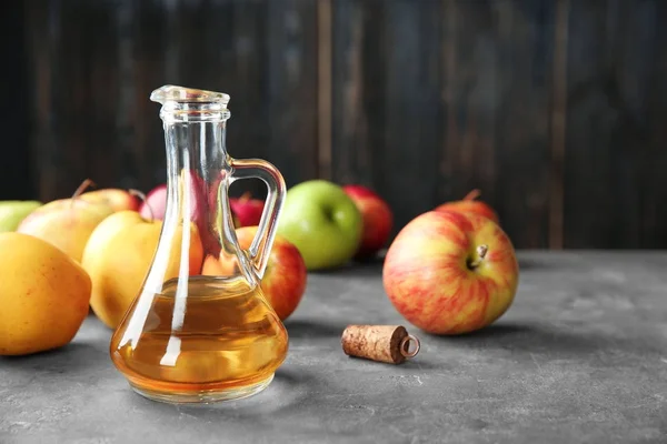 Brocca di vetro con aceto di mele e frutta fresca in tavola — Foto Stock
