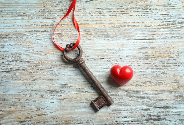 Old key and red heart on wooden background — Stock Photo, Image