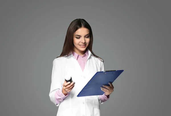 Jeune Pharmacienne Avec Médicament Presse Papiers Sur Fond Gris — Photo