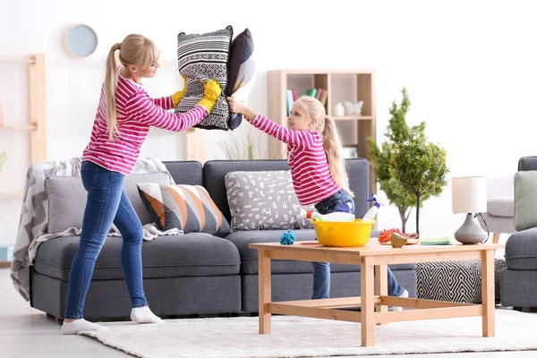 Kis lány és az anyja, miközben takarítás otthon játszik — Stock Fotó