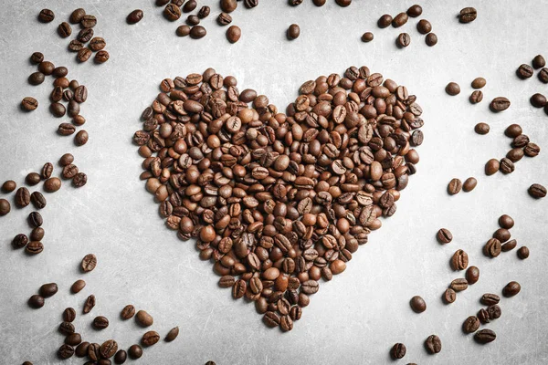 Heart made of coffee beans on light background — Stock Photo, Image