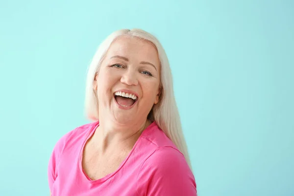 Portrait of happy mature woman on color background — Stock Photo, Image