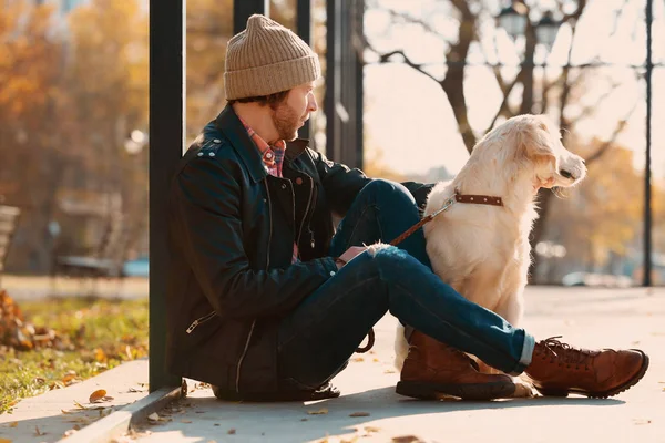 Guapo joven hipster con perro al aire libre —  Fotos de Stock