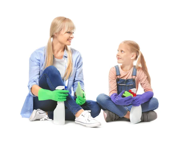 Kleines Mädchen und ihre Mutter mit Putzutensilien auf weißem Hintergrund — Stockfoto