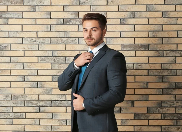 Bello uomo in abito formale contro muro di mattoni — Foto Stock