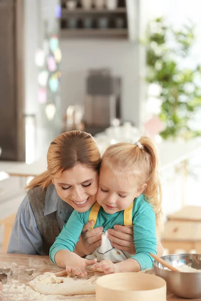 Mãe e filha com massa de farinha à mesa em casa — Fotografia de Stock