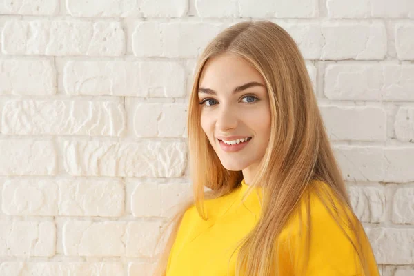 Uśmiechnięta Kobieta Żółtą Bluzę Tle Ściany Cegła — Zdjęcie stockowe
