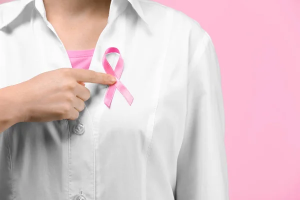 医生在颜色背景上显示粉红色缎带。乳癌意识概念 — 图库照片
