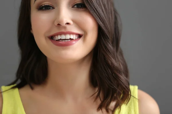 Joven hermosa mujer sonriente sobre fondo gris, primer plano —  Fotos de Stock