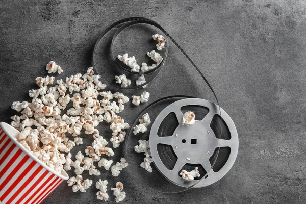 Pappersmugg Med Läckra Popcorn Och Film Rulle Grå Bakgrund — Stockfoto