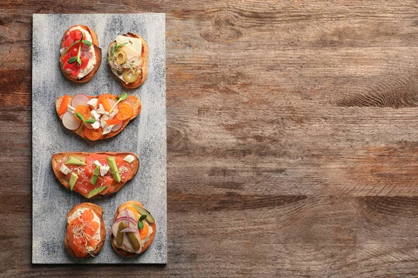 Plateau avec de savoureux bruschettas frais sur la table — Photo