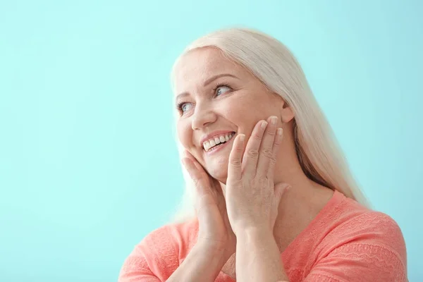 Portret van mooie rijpe vrouw op kleur achtergrond — Stockfoto