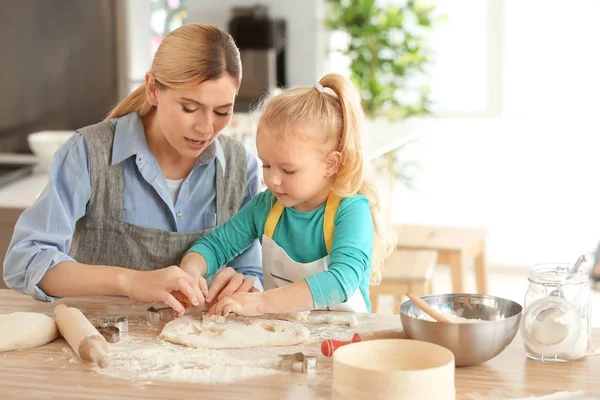 Mother and daughter with dough at table indoors — Stock Photo, Image