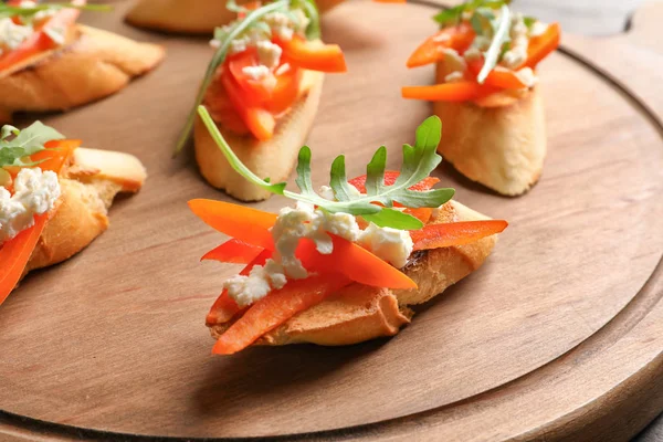 Wooden board with tasty fresh bruschettas, closeup — Stock Photo, Image